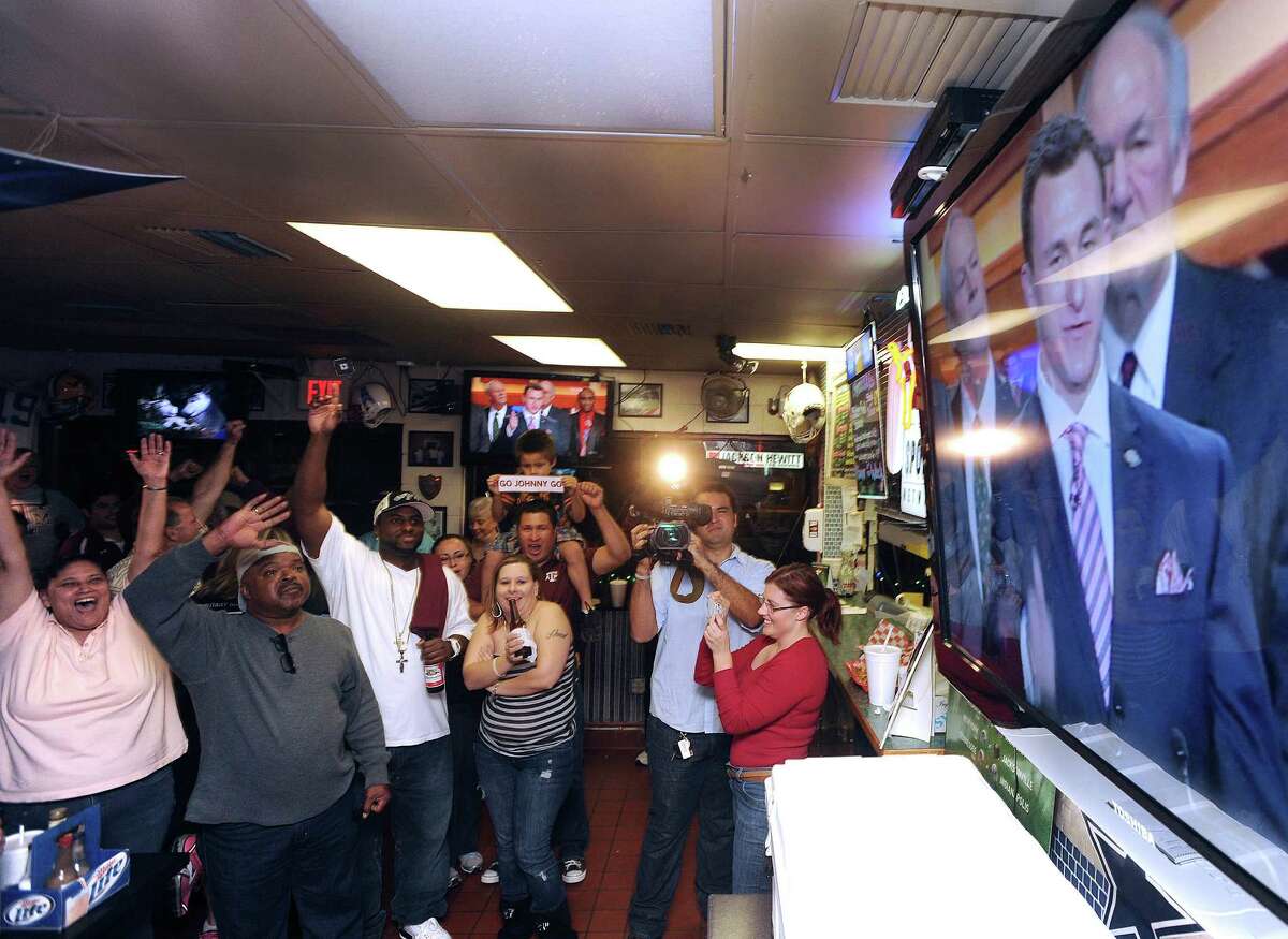 Fans of Texas A&M quarterback Johnny Manziel watch as Manziel accepts the Heisman trophy on televison at the Wing King restaurant in Kerrville on Saturday night, Dec. 8, 2012. Manziel played high school football for Tivy High School in Kerrville.