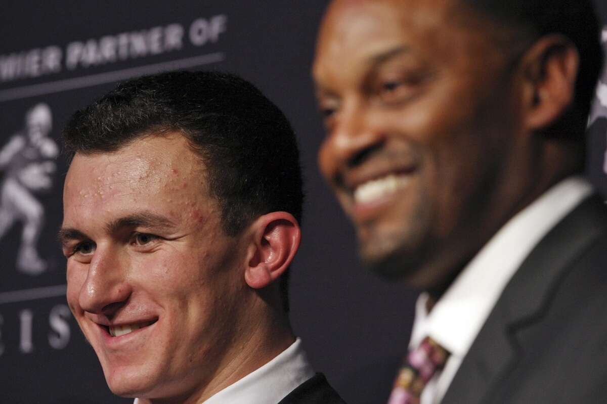 Texas A&M's quarterback Johnny Manziel, the 2012 Heisman Trophy winner, (left) and Texas A&M's headcoach Kevin Sumlin answers questions from the media during a press conference Saturday Dec. 8, 2012 at the New York Marriott Marquis hotel in New York, New York.