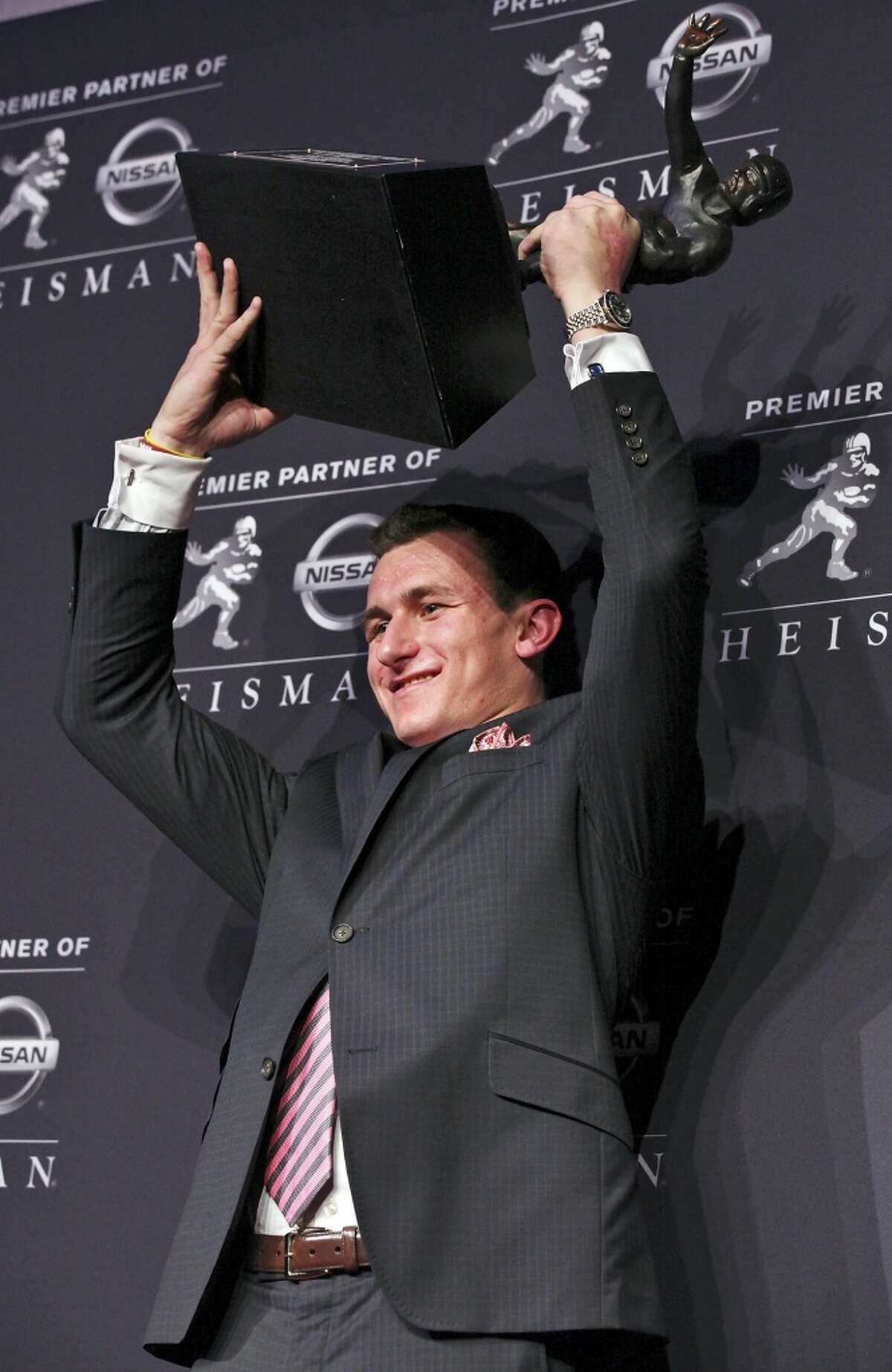 Texas A&M's quarterback Johnny Manziel, the 2012 Heisman Trophy winner, poses for photos during a press conference Saturday Dec. 8, 2012 at the New York Marriott Marquis hotel in New York, New York.