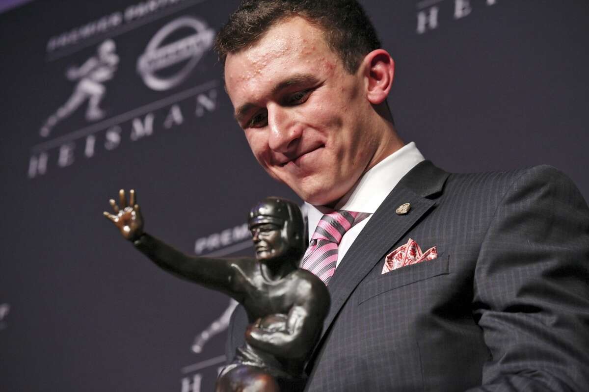 Texas A&M's quarterback Johnny Manziel, the 2012 Heisman Trophy winner, poses for photos during a press conference Saturday Dec. 8, 2012 at the New York Marriott Marquis hotel in New York, New York.