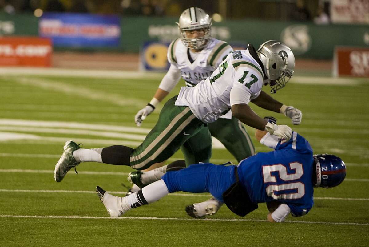 De La Salle High School's, Michael Hutchings (17), knocks Folsom High School's, Troy Knox (20), to the ground after his catch as De La Salle-Concord plays Folsom High School for the first ever Sac Joaquin Section open division Northern California football championship game at Hornet Stadium in Sacramento, Saturday Dec 8, 2012. The winner will travel to Carson California for the state Championship game.