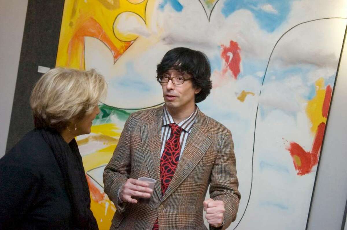 Sandy Goldstein, President of the Stamford Downtown Special Services District, left, speaks with painter, Fernando Luis Alvarez, right, during the opening of his new gallery at 96 Bedford Street, Stamford on Thursday evening December 17, 2009.
