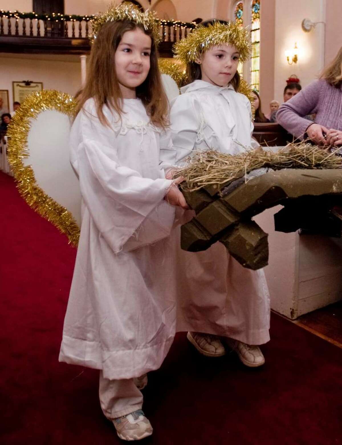 5 year old Brooke Brescia and 6 year old Julia Waters, both of Bethel, carry the manger during the First Congregational Church children's Christmas pageant presented by the Children of the Church School. Sunday, Dec. 13, 2009