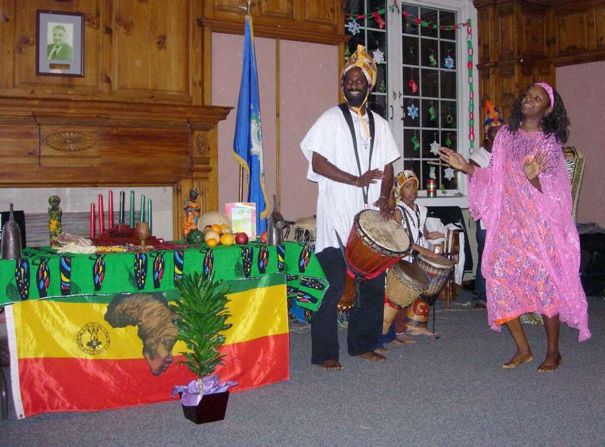 Kojo Bey, left,artistic director for Sounds of Afrika on the drum, his wife Franchone Bey, right. Center, is Khalfani Drakeford , a young drummer. They are performing during a Kwanzaa celebration last year.