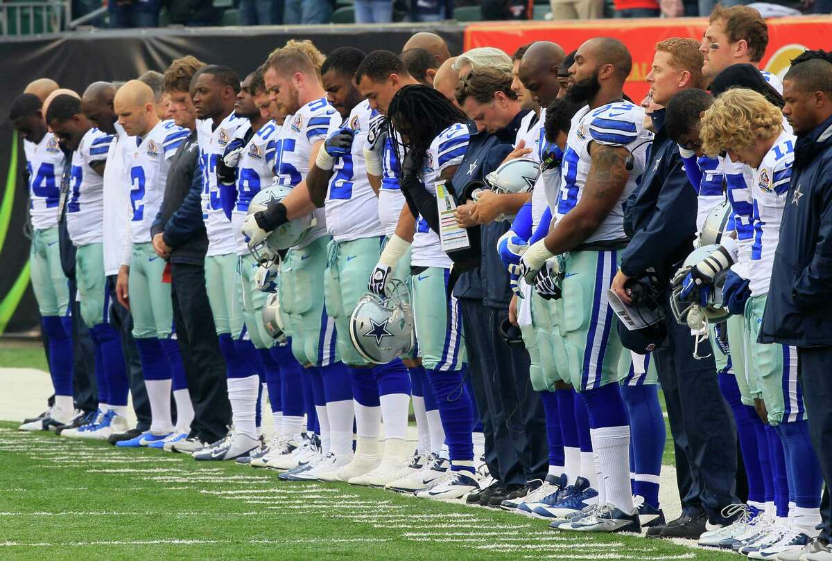 Dallas Cowboys players hang their heads during a moment of silence honoring teammate Jerry Brown who was killed in an automobile accident prior to an NFL football game against the Cincinnati Bengals, Sunday, Dec. 9, 2012, in Cincinnati. (AP Photo/Al Behrman)