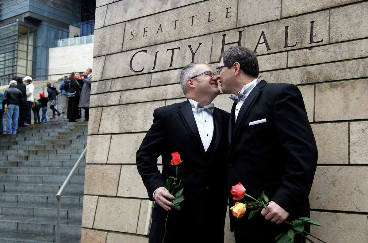 Terry Gilbert, left, kisses his husband Paul Beppler after wedding at Seattle City Hall, becoming among the first gay couples to legally wed in the state, Sunday, Dec. 9, 2012, in Seattle. Gov. Chris Gregoire signed a voter-approved law legalizing gay marriage Dec. 5 and weddings for gay and lesbian couples began in Washington on Sunday, following the three-day waiting period after marriage licenses were issued earlier in the week. (AP Photo/Elaine Thompson)
