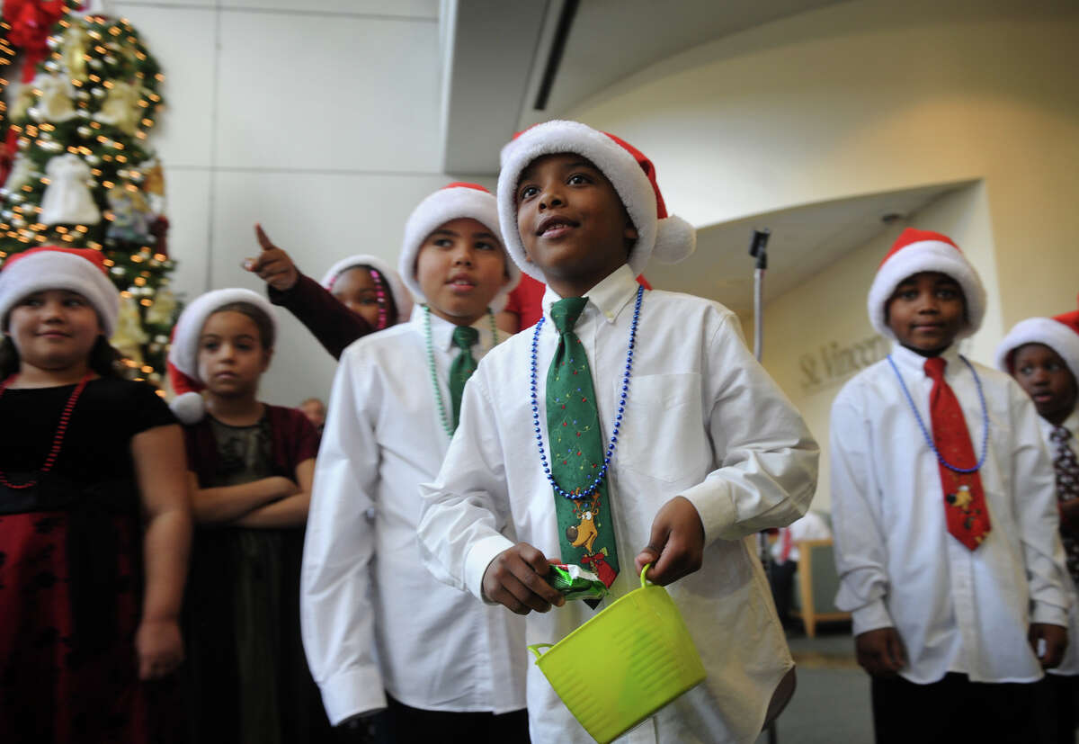Wilbur Cross School second grader Jordan Baskin looks to hand a present to a person in the audience during a performance by his class in the lobby of St. Vincent's Hospital in Bridgeport on Tuesday, December 11, 2012.