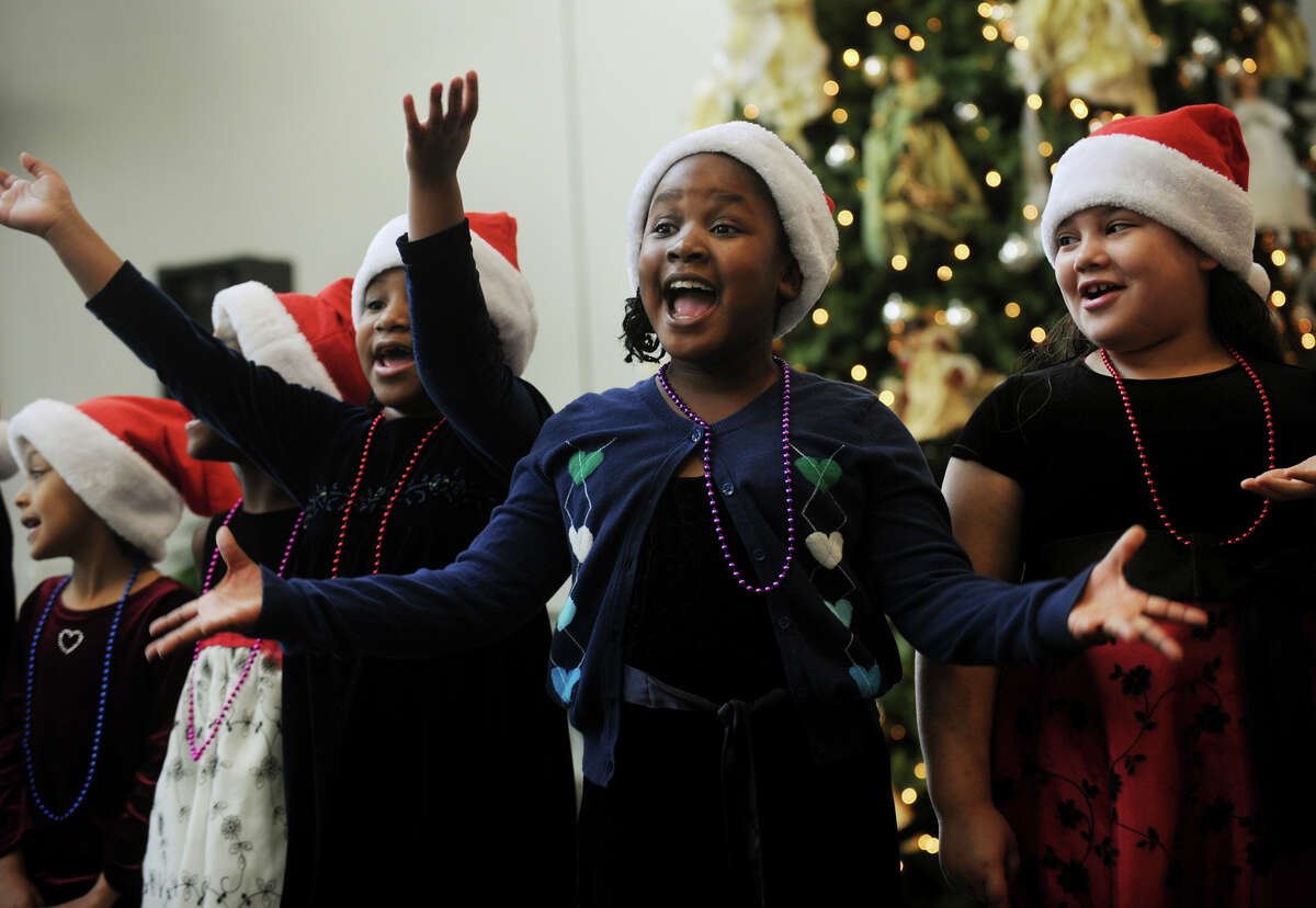 From left; Chanise Ninnott, 7, Kalei Hill, 7, and Angelis Hernandez, 8, second graders in Candie Veccharelli's class at Wilbur Cross School in Bridgeport, perform in the lobby of St. Vincent's Hospital in Bridgeport on Tuesday, December 11, 2012.