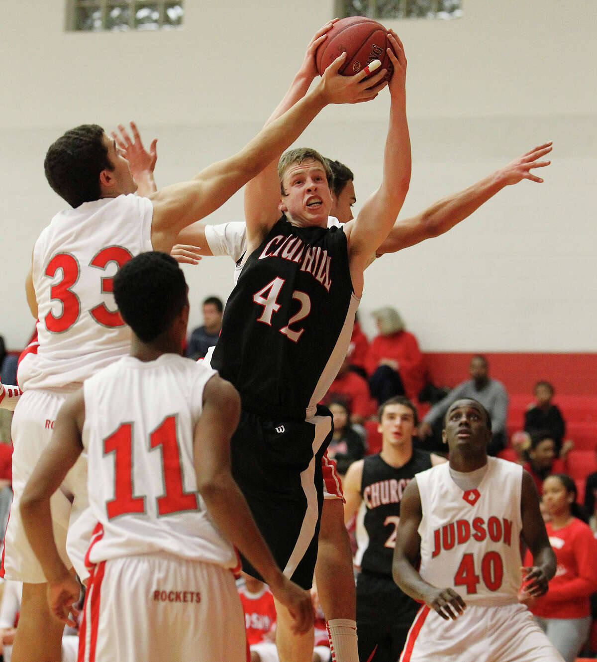 Churchill's Brian Herring (42) grabs a rebound against a gropu of Judson players including David Wacker (33) during their non-district game at Judson on Tuesday, Dec. 11, 2012. Churchill defeated Judson, 57-54.