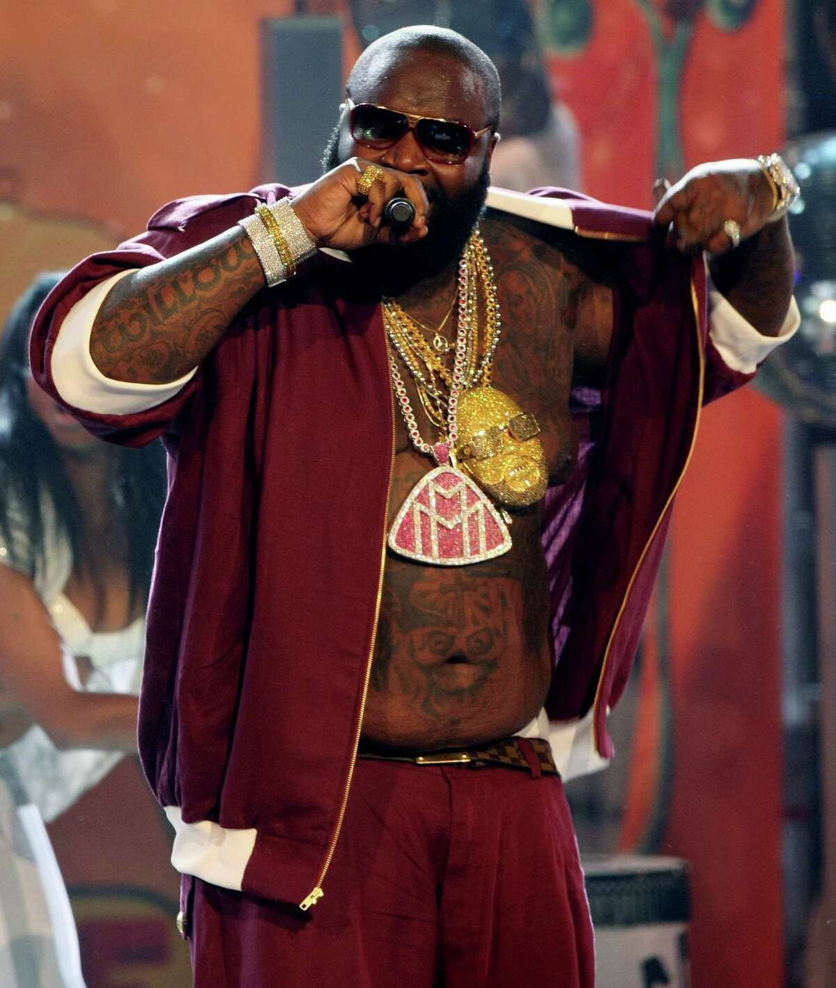 FILE-This June 24, 2008 file photo shows Rick Ross performing at the BET Awards in Los Angeles. Tamara Connor, an Atlanta-based stylist who's created looks for chart topping rappers like Lil Wayne, says artists are saving money by doing photo shoots with fewer of the pricey, specialized medallions considered a calling card among popular rap celebrities like Ross. (AP Photo/Hector Mata,File)
