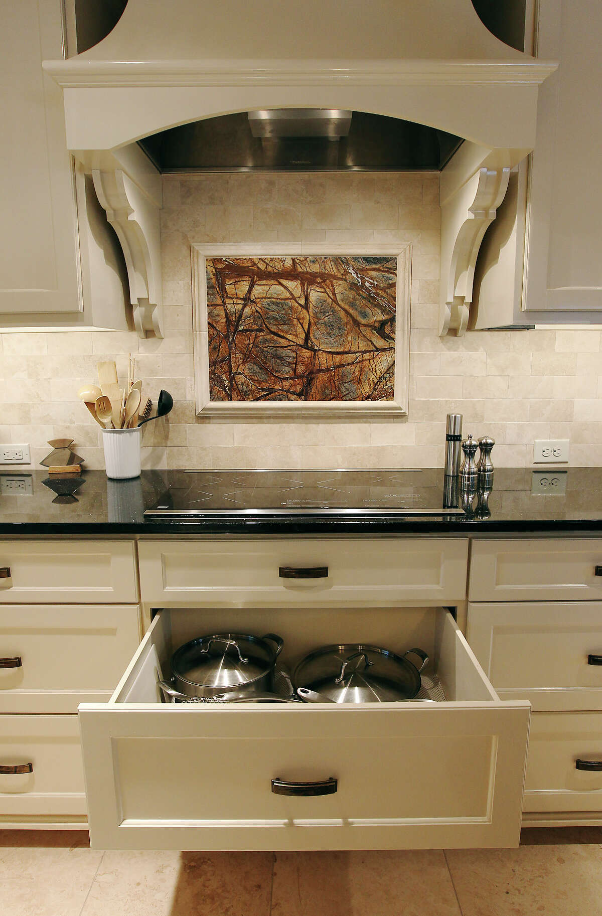 Linda and Bill Blanton's newly remodeled kitchen in Pleasanton, Texas on Tuesday, Nov. 27, 2012. Under the electric range top are drawers for the Blantons to store pots and pans. On the back splash is a granite insert that matches the kitchen island.