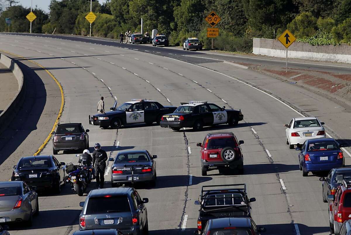 The California Highway Patrol blocks traffic as the Oakland Police Department searches for a suspect in a home invasion and armed robbery, Monday, Dec. 10, 2012.