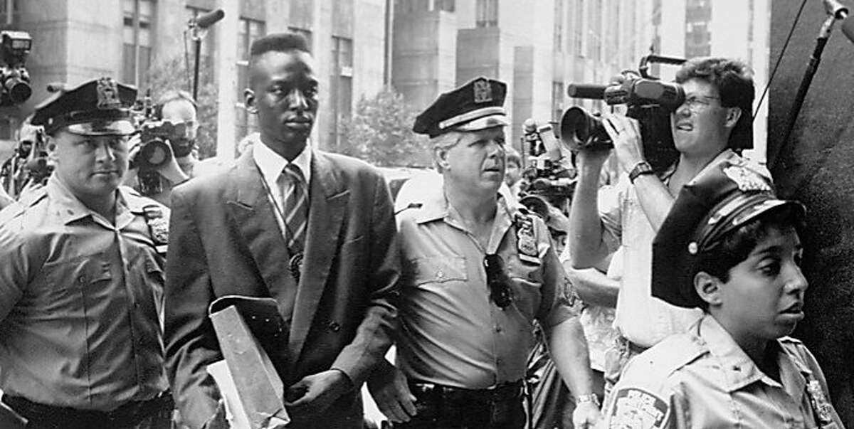 Defendant Yusef Salaam walks into courthouse flanked by police officers in Ken Burns, Sarah Burns and David McMahon?•s THE CENTRAL PARK FIVE.