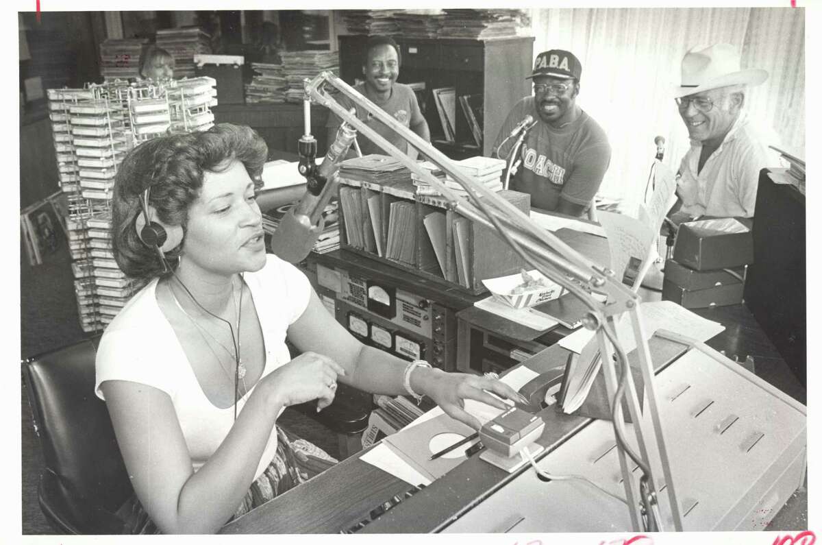 HOUCHRON CAPTION (09/02/1982): Cassandra Domanguex, a disc jockey at KCOH, accepts pledges on the air during a radiothon to benefit the Progressive Amateur Boxing Association, while, from left, KCOH disc jockey Joe Williams, the Rev. Ray Martin, and former Police Chief B.K. Johnson look on.