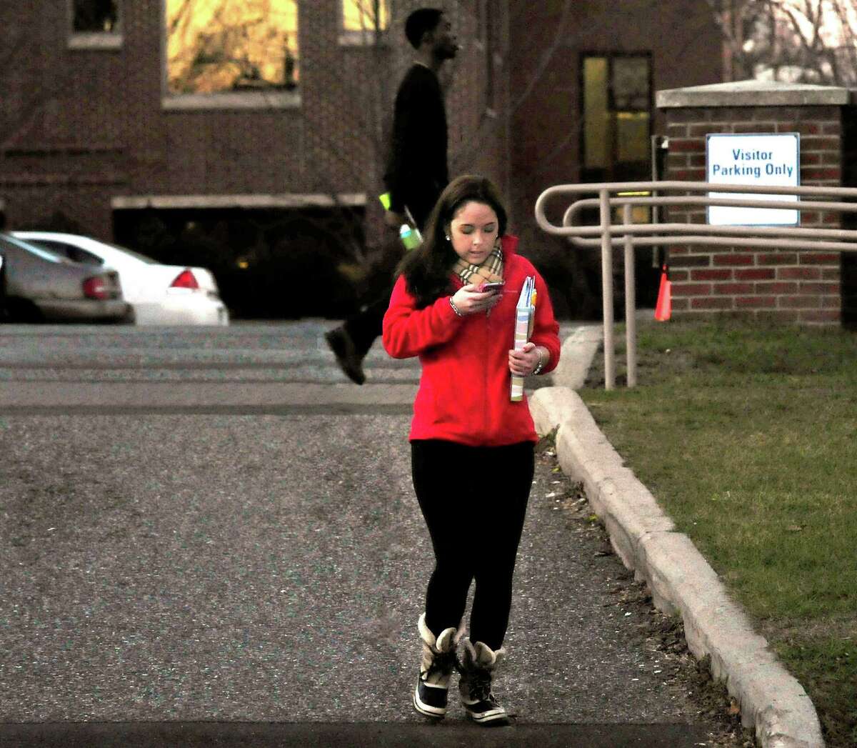 A woman is texting while crossing White Street in Danbury Thursday, Dec. 13, 2012.