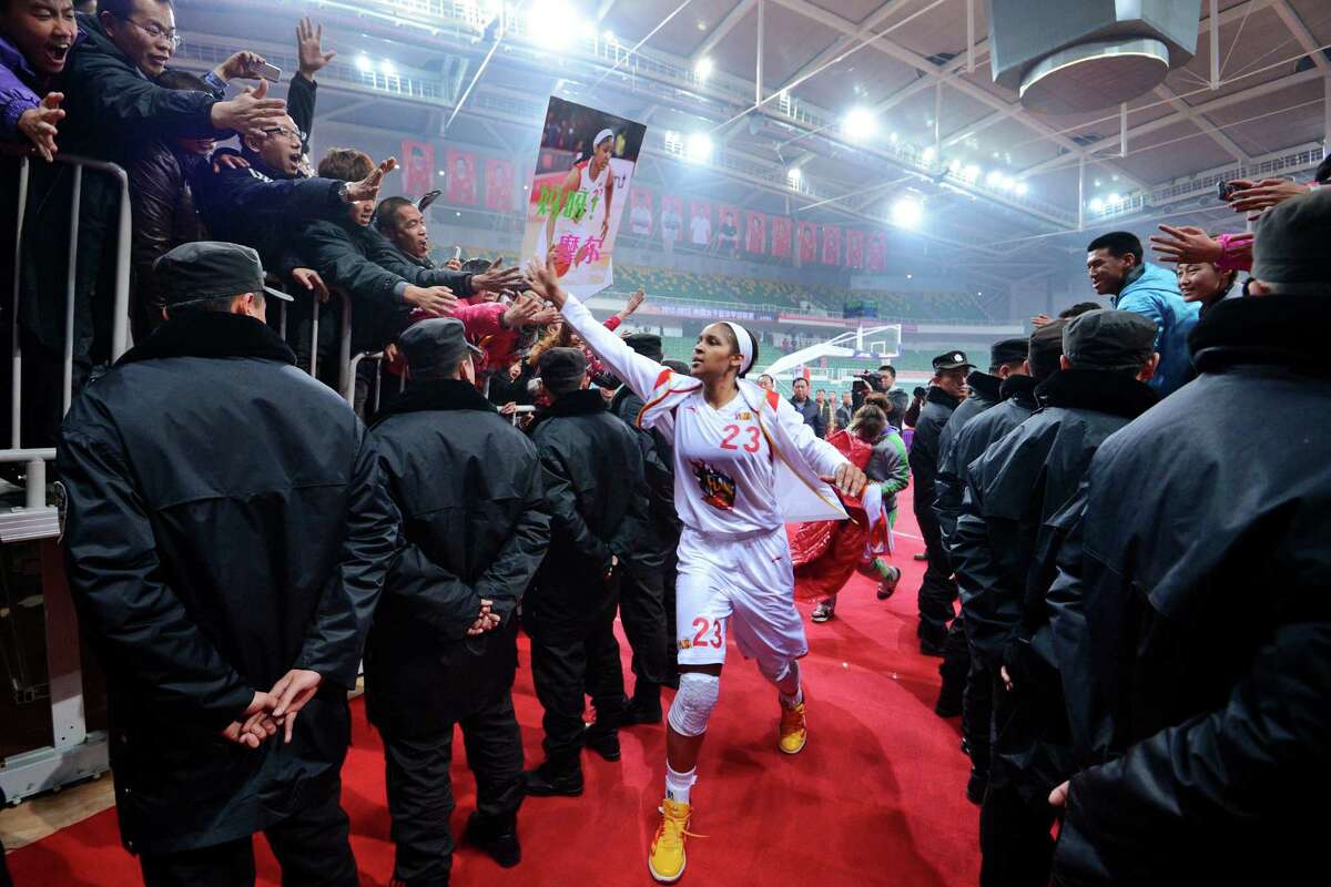 In this Nov. 24, 2012, photo, Shanxi Flame's Maya Moore greets fans as she prepares to take the court for a WCBA basketball game against the Jiangsu Dragons in Taiyuan, China. While her Minnesota Lynx team awaits the return of WNBA training camp in May, Moore is averaging 45 points a game and earning mid-six figures for the Flame, helping bring new fans to the women's game in a baseball crazed nation. (AP Photo/CHINATOPIX) CHINA OUT