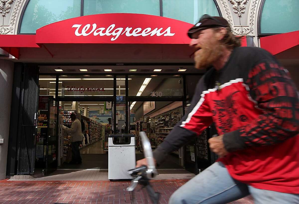 In this file photo, a bicyclist rides by a Walgreens store in San Francisco.  Walgreens has over 67 locations in the city.