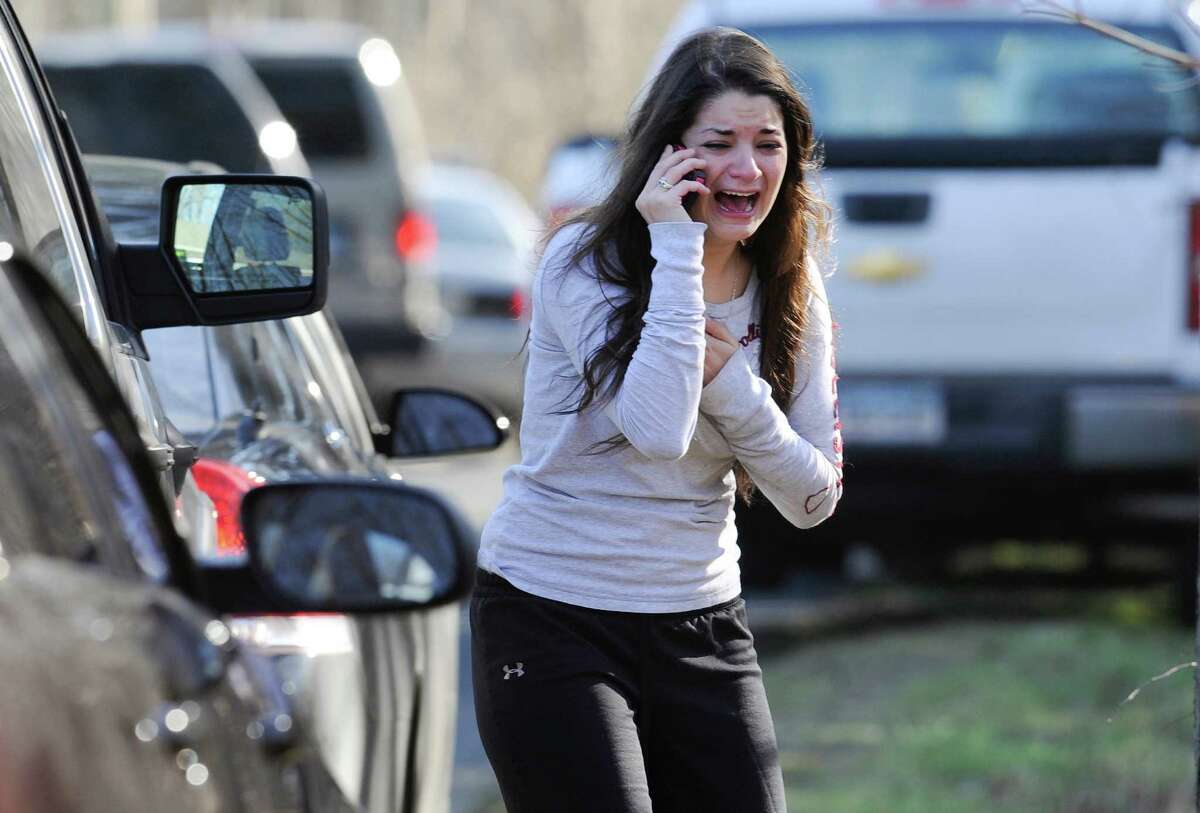 A woman waits to hear about her sister, a teacher, following a shooting at the Sandy Hook Elementary School in Newtown, Conn., about 60 miles (96 kilometers) northeast of New York City, Friday, Dec. 14, 2012. An official with knowledge of Friday's shooting said 27 people were dead, including 18 children. It was the worst school shooting in the country's history.