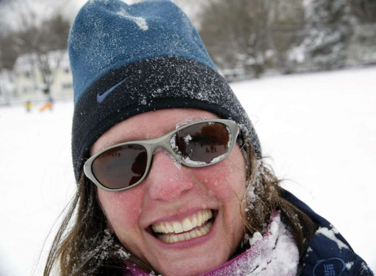 A snow faced Sandy farber smiles after sledding down the hill at Sturges Park in fairfield with her son Devyn, 3, Sunday, Dec. 20, 2009.