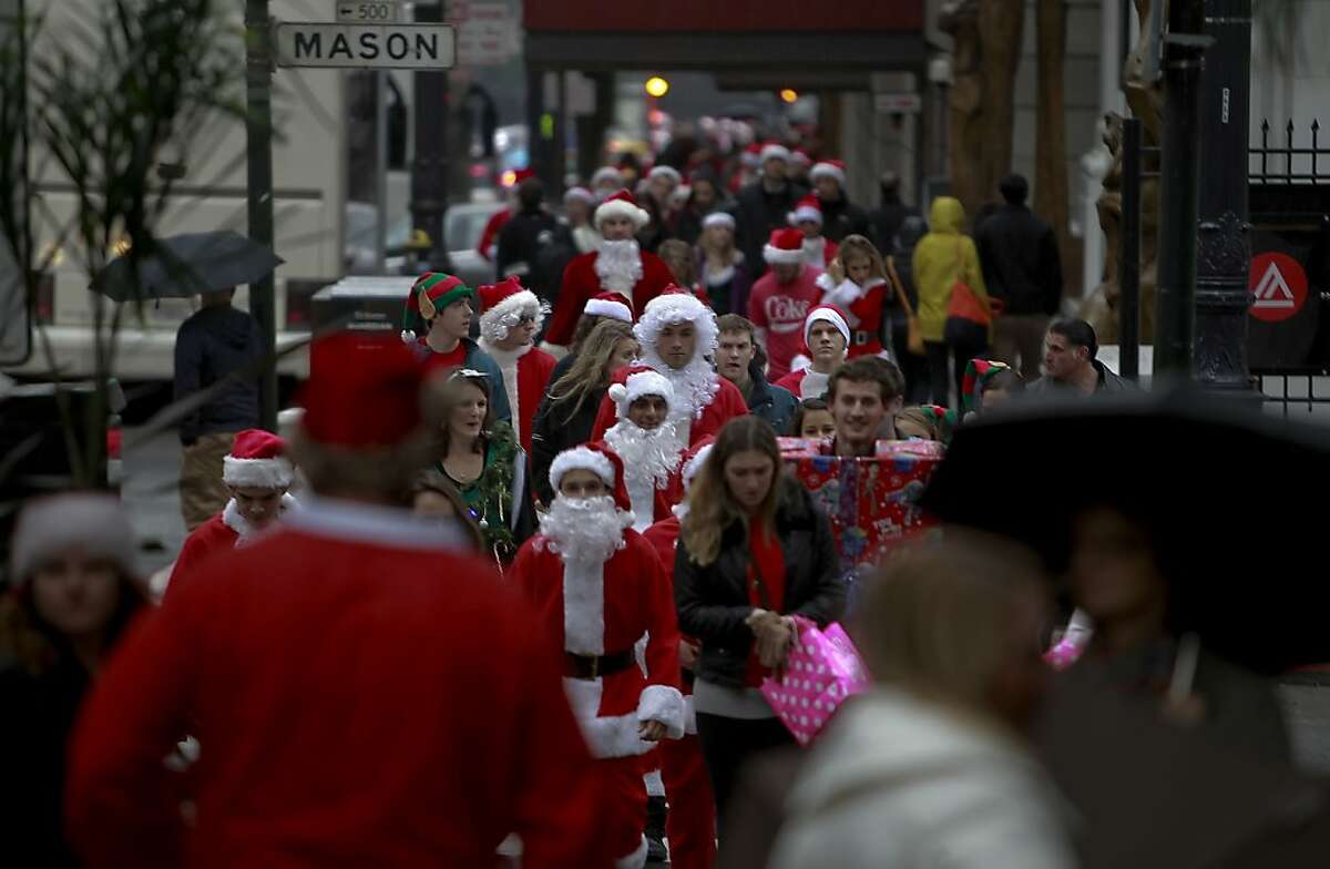 Santas walk the downtown of San Francisco as the annual Santacon event kicked off at Union Square and then turned to pub crawls around the city on Saturday Dec. 15, 2012 in San Francisco, Calif.