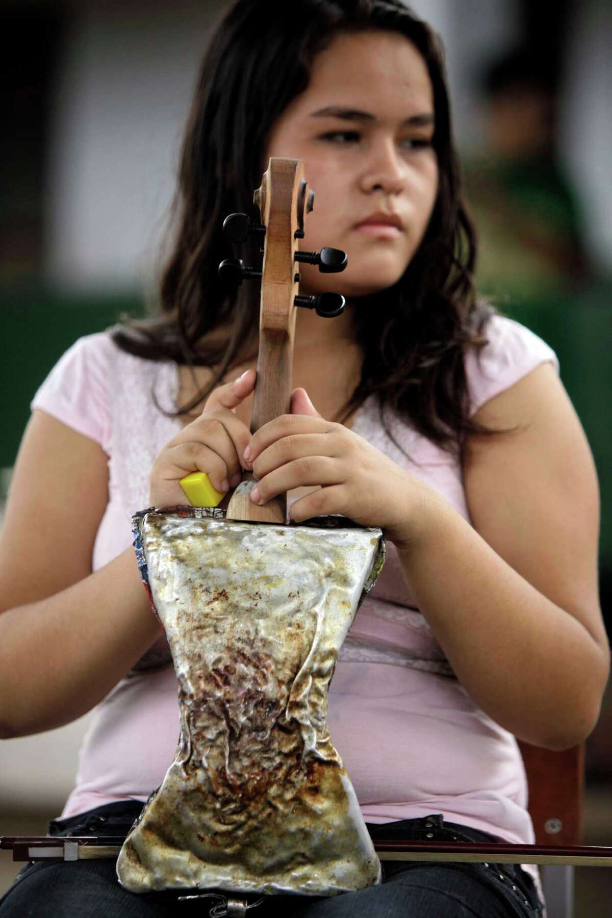 Kids play Mozart with violins made from garbage