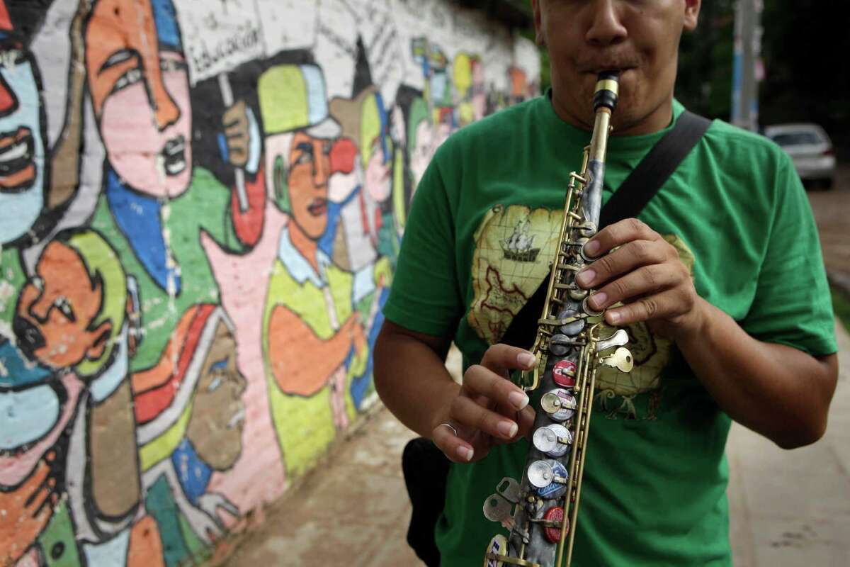 Kids play Mozart with violins made from garbage