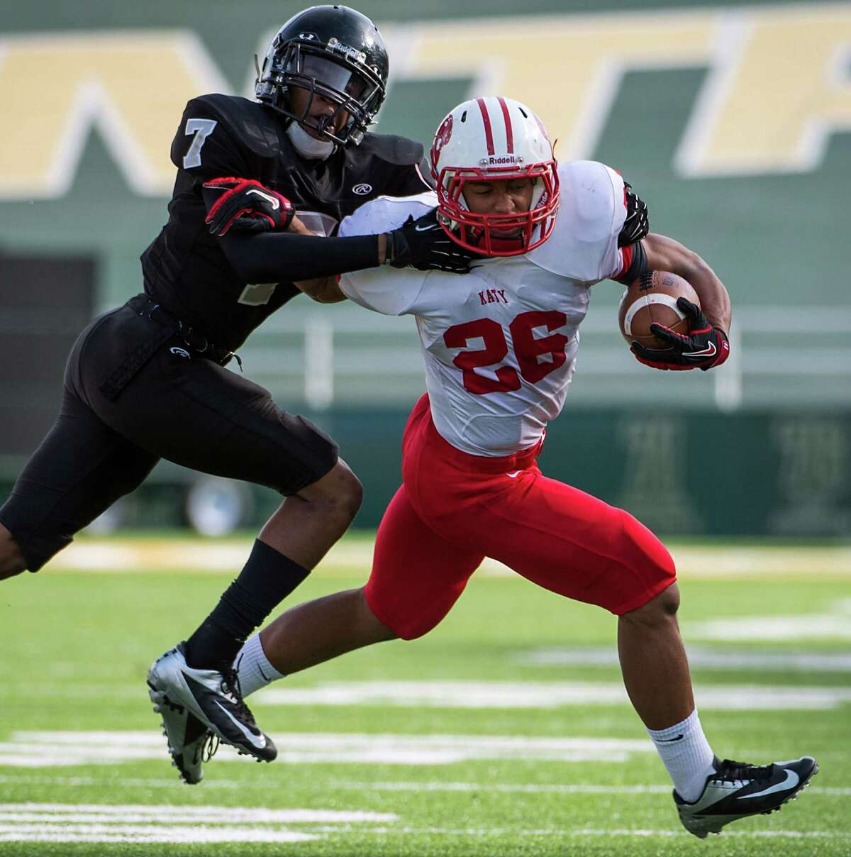 Katy running back Rodney Anderson (26) is tackled by Cibolo Steele defensive back Carl Cunningham (7) during the first quarter in a Class 5A Division II state high school football semifinal game at Floyd Casey Stadium on Saturday, Dec. 15, 2012, in Waco. ( Smiley N. Pool / Houston Chronicle )