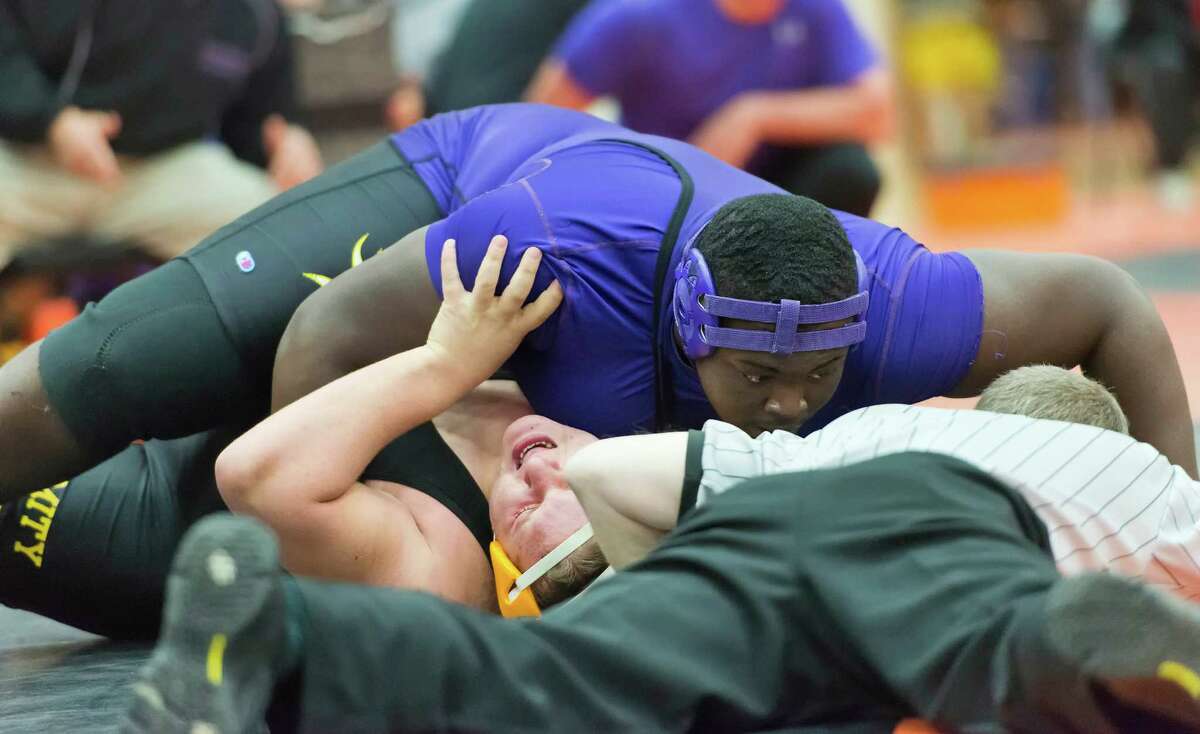 In the 285lb weight class matach at the Shelton invitational wrestling tournament Westhill high school's Ron Griggs waits for the referee's hand to go down to indicate a pin in a match against Amity high school's Nick Photos. The tournament was held at Shelton high school, Shelton, CT on Saturday, December 15th, 2012