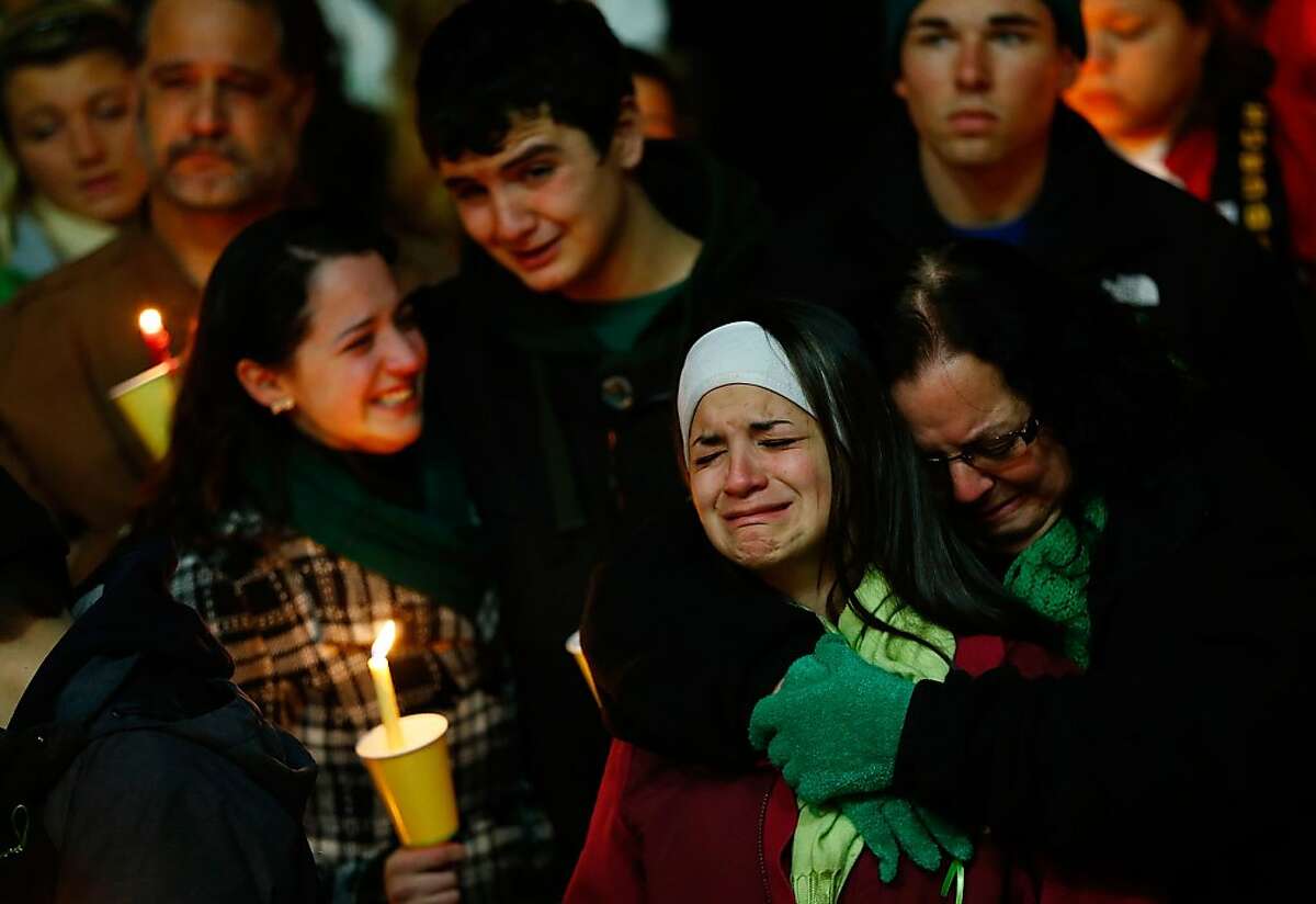 STRATFORD, CT - DECEMBER 15: Donna Soto (R), mother of Victoria Soto, the first-grade teacher at Sandy Hook Elementary School who was shot and killed while protecting her students, hugs her daughter Karly (second from right) while mourning their loss with Victoria's other two siblings, Jillian (far left) and Matthew Soto (second from left), at a candlelight vigil at Stratford High School on December 15, 2012 in Stratford, Connecticut. Twenty-six people were shot dead, including twenty children, after a gunman identified as Adam Lanza opened fire in the school. Lanza also reportedly had committed suicide at the scene. A 28th person, believed to be Nancy Lanza was found dead in a house in town, was also believed to have been shot by Adam Lanza. (Photo by Jared Wickerham/Getty Images)