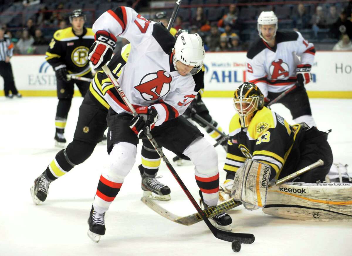 Devils' Chris McKelvie (37), center, works the puck as Bruins goalie Michael Hutchinson (33), right, guards the net during their hockey game on Saturday, Dec. 15, 2012, at Times Union Center in Albany, N.Y. (Cindy Schultz / Times Union)