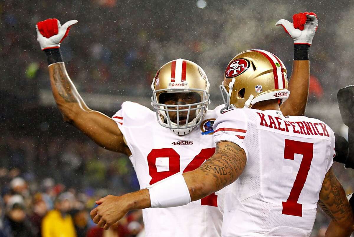 49ers wide receiver Randy Moss, left, celebrates with quarterback Colin Kaepernick after scoring a touchdown in the first quarter against the Patriots at Gillette Stadium on December 16, 2012 in Foxboro, Mass.