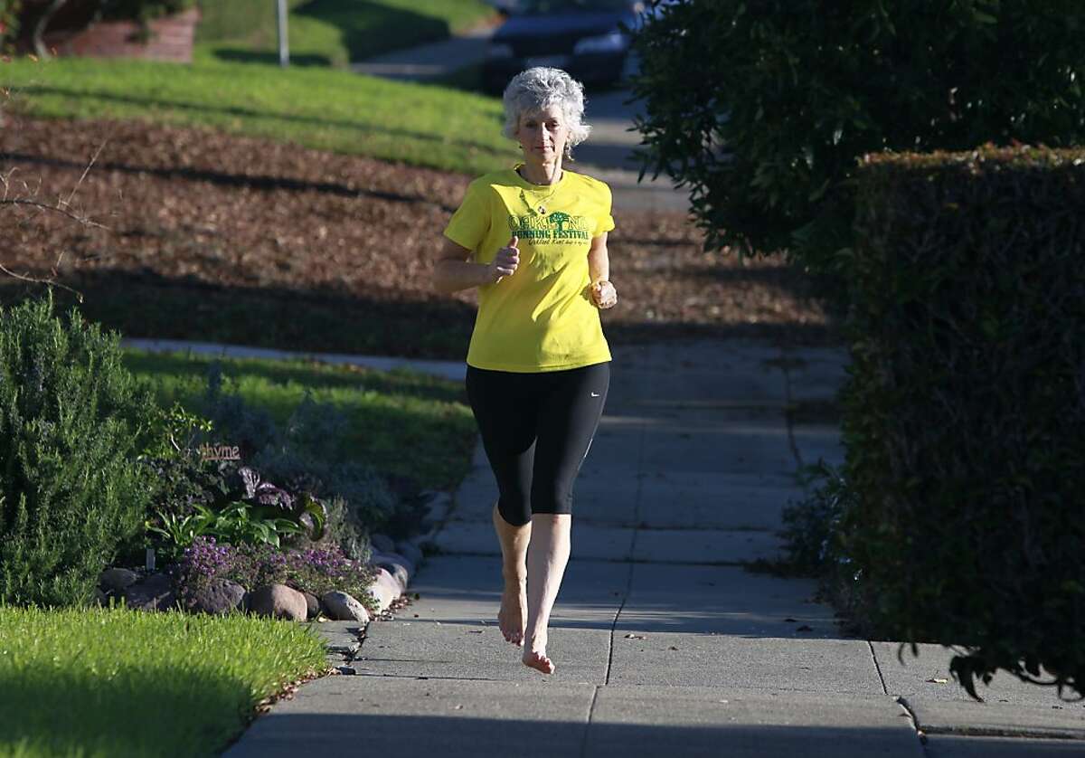 Jan Hetherington jogs through her neighborhood running barefoot in Oakland, Calif. on Tuesday, Dec. 11, 2012.