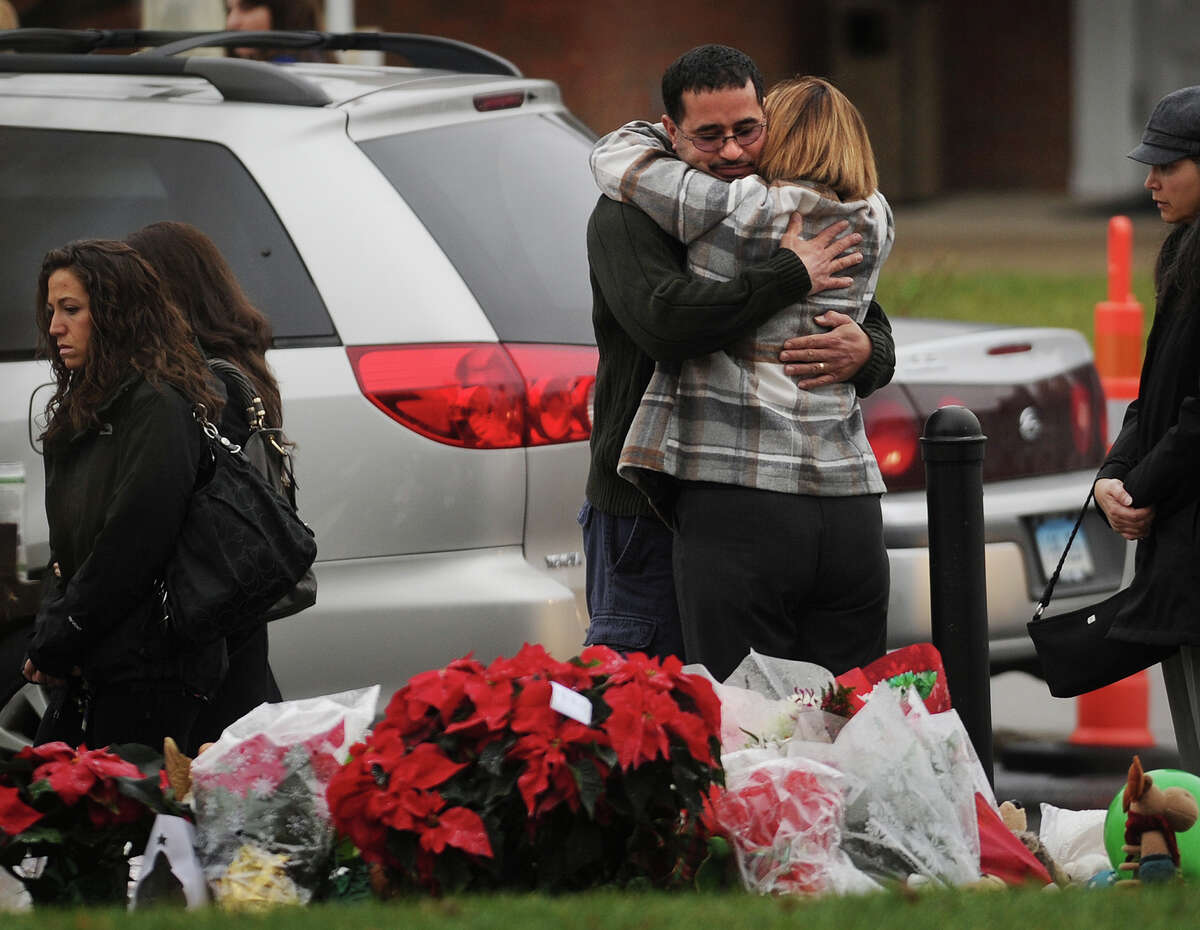Mourners embrace outside the funeral of James R. Mattioli, one of the children killed in the Sandy Hook Elementary School shootings, at St. Rose of Lima Catholic Church in Newtown on Tuesday, December 18, 2012.