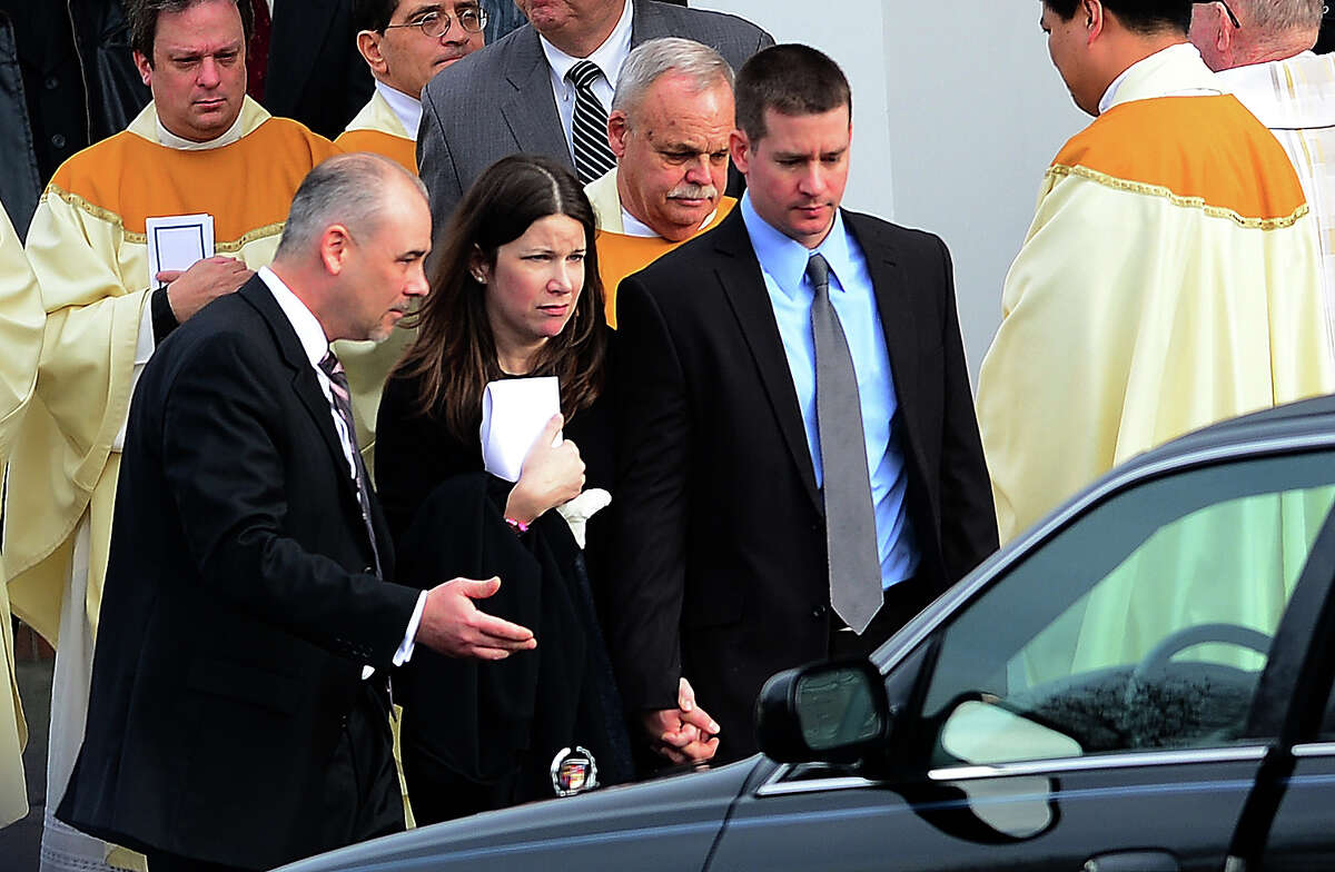 Richard (R) and Krista Rekos, the parents of Jessica Rekos, 6, one of the 20 children killed in an elementary school shooting, leave after a funeral service at Saint Rose of Lima Church on December 18, 2012 in Newtown, Connecticut. Most children in Newtown returned to classes for the first time since last week's massacre, but survivors of the shooting stayed at home and their school remained a crime scene. In a thin drizzle, yellow school buses once again rolled through the Connecticut town, where some 5,400 children are enrolled. AFP PHOTO/EMMANUEL DUNAND