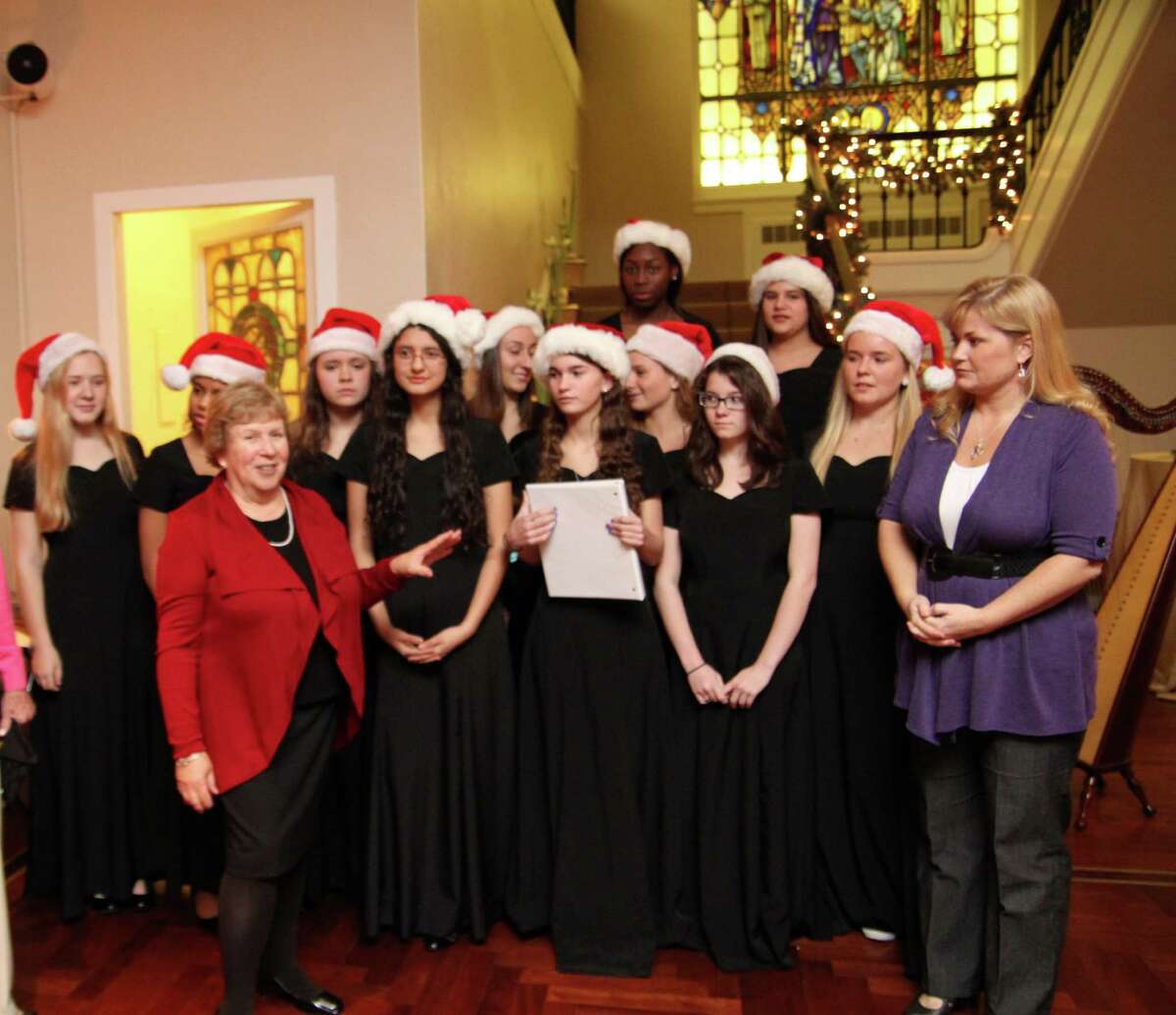 Convent of the Sacred Heartís Madrigals singing group will sing "Carol of the Bells" live on NBCís ìTodayî show at 9 a.m. Thursday, Dec. 20, 2012, outside NBC Studios at 30 Rockefeller Plaza in New York City. The performance will be broadcast around the country. Pictured here Dec. 8, Jayne Collins, left in red, the head of the Upper School at Convent of the Sacred Heart, announces that the madrigals, wearing black, would perform on the show. At right is Music Director Annette Etheridge.