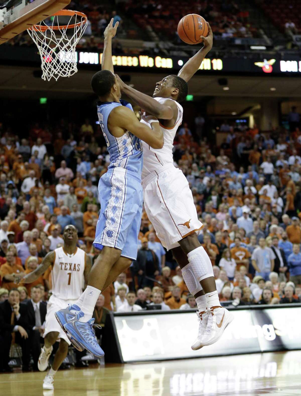 Texas' Jonathan Holmes, right, scores over North Carolina's J.P. Tokoto, left, during the second half of an NCAA college basketball game on Wednesday, Dec. 19, 2012, in Austin, Texas. Texas won 85-67. (AP Photo/Eric Gay)