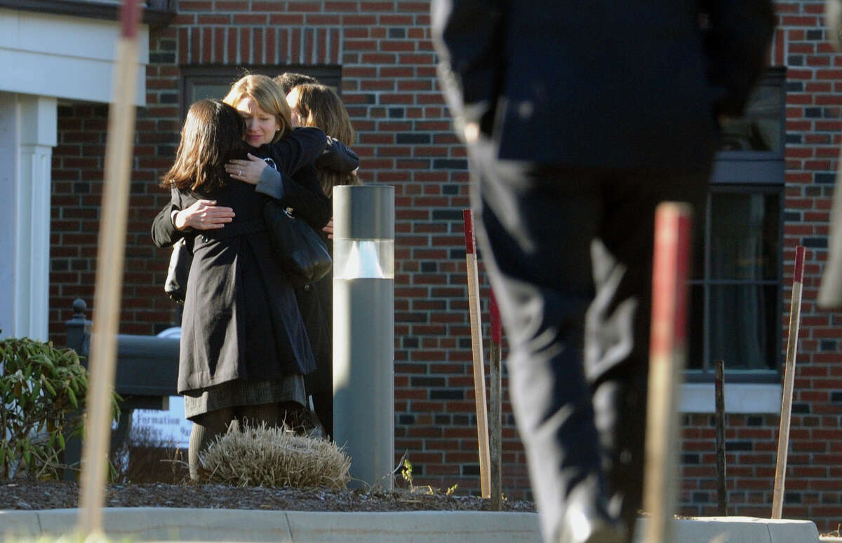 Mourners embrace as they arrive for the funeral for Sandy Hook Elementary School student Allison Wyatt which was held at Sacred Heart Roman Catholic Church in Southbury Conn. on Thursday December 20, 2012.