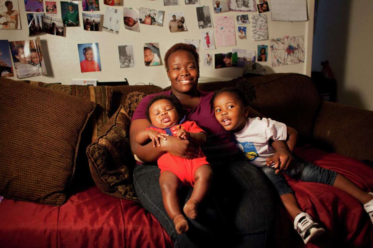 Twanna Davis holds her 4 1/2-month-old son, Kaleb Davis-Ford, left, and her 3-year-old daughter, Jazzlyn Davis, on the couch beside her Friday, Dec. 14, 2012, at their home in Houston. The Davis family are second year recipients of the Goodfellows program, which provides new holiday toys to children in need. Davis does not have a job because the price of childcare outweighs what she would make in income. The Goodfellows program is run by the Houston Chronicle and all funds are donated by Chronicle readers, employees and business partners and are used entirely to purchase toys. Last year, Houston's generosity enabled Goodfellows to provide toys to nearly 60,000 children in almost 18,000 families. (Alyssa Orr / Houston Chronicle)