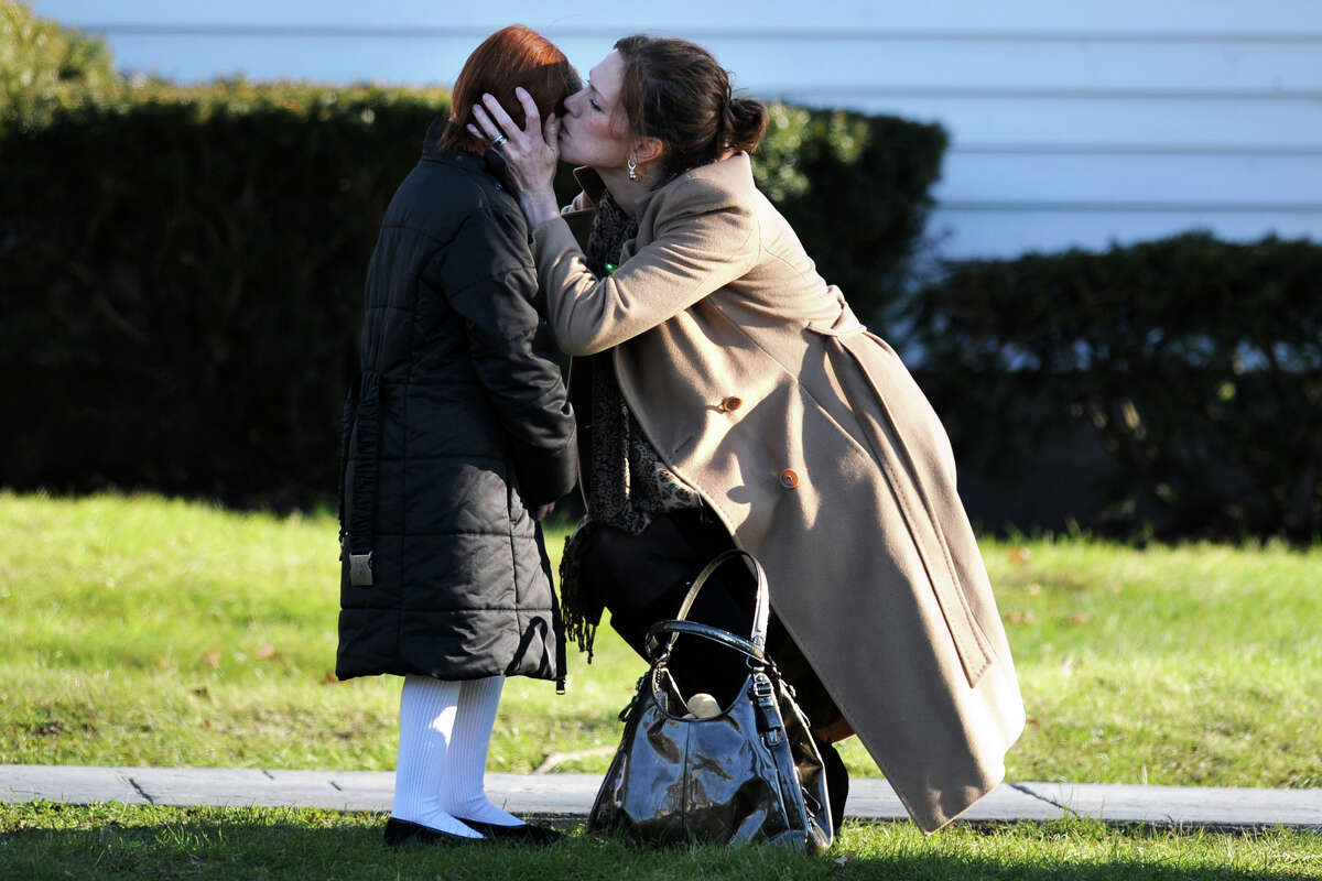 A woman kisses a young girl after leaving the funeral service for Jesse McCord Lewis, at the Honan Funeral Home in Newtown, Conn., Dec. 20th, 2012. Lewis is one of twenty students killed in the mass shooting at Sandy Hook Elementary School last Friday.