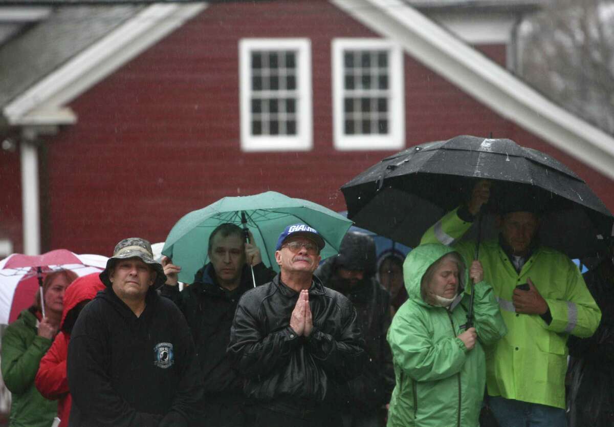 People, including Joe Saleem, center, observe a moment of silence led by Connecticut Governor Dannel Malloy, Lt. Governor Nancy Wyman and First Selectman Patricia Llodra in front of Edmond Town Hall in Newtown. The moment of silence and bell tolling was held across the state on Friday, December 21, 2012, the one week anniversary of the Sandy Hook shootings. Saleem said he lived in Newtown for 54 years but moved to North Carolina. But after the violence that took 28 people, Saleem returned to his hometown. "I've had three sleepless nights," he said.