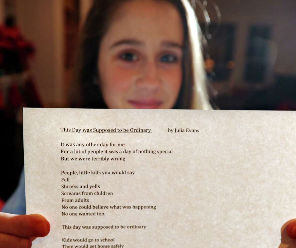 Julia Evans, 12, of Old Greenwich, holds her poem about the Sandy Hook Elementary School massacre titled "The Day was Suppose to be Ordinary," at her home, Thursday night, Dec. 20, 2012. Evans is a 7th grader at Greenwich Country Day School.