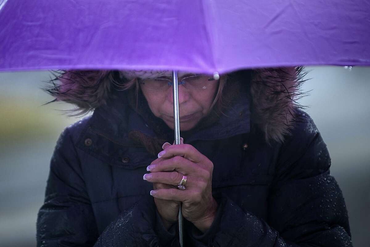 A woman bows her head during a moment of silence in Sandy Hook village on December 21, 2012 in Newtown, Connecticut. People around the United States joined in a moment of silence at 9:30 am to mark the one week anniversary of the Sandy Hook Elementary School shootings, while bells also rang 26 times to honor the victims of alleged gunman Adam Lanza, not including his mother Nancy Lanza who was killed at their family home. AFP PHOTO/Brendan SMIALOWSKIBRENDAN SMIALOWSKI/AFP/Getty Images