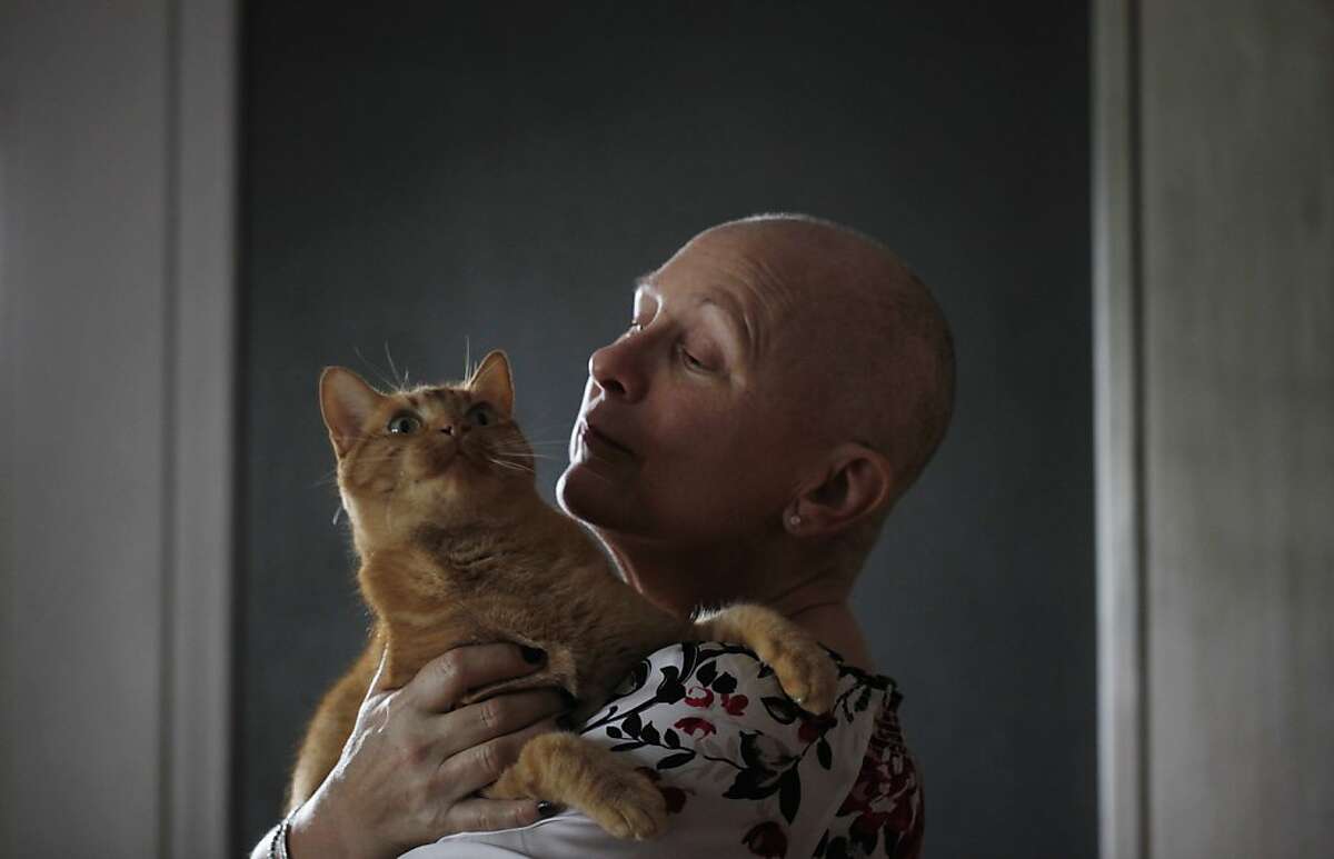 Season of Sharing recipient Anne Knudsen Baldwin, who is battling cancer, holds her cat Ginger at on Monday Dec. 17, 2012 in Sunnyvale, Calif.