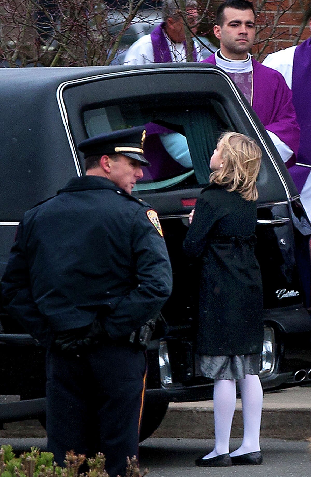 A little girl looks into the hearse carrying the casket of Josephine Gay after her funeral at St. Rose of Lima Roman Catholic Church, Saturday, Dec. 22, 2012, in Newtown. Gay was one of 26 killed after gunman Adam Lanza opened fire killing 26 individuals, 20 whom were children, at Sandy Hook Elementary School last Friday.