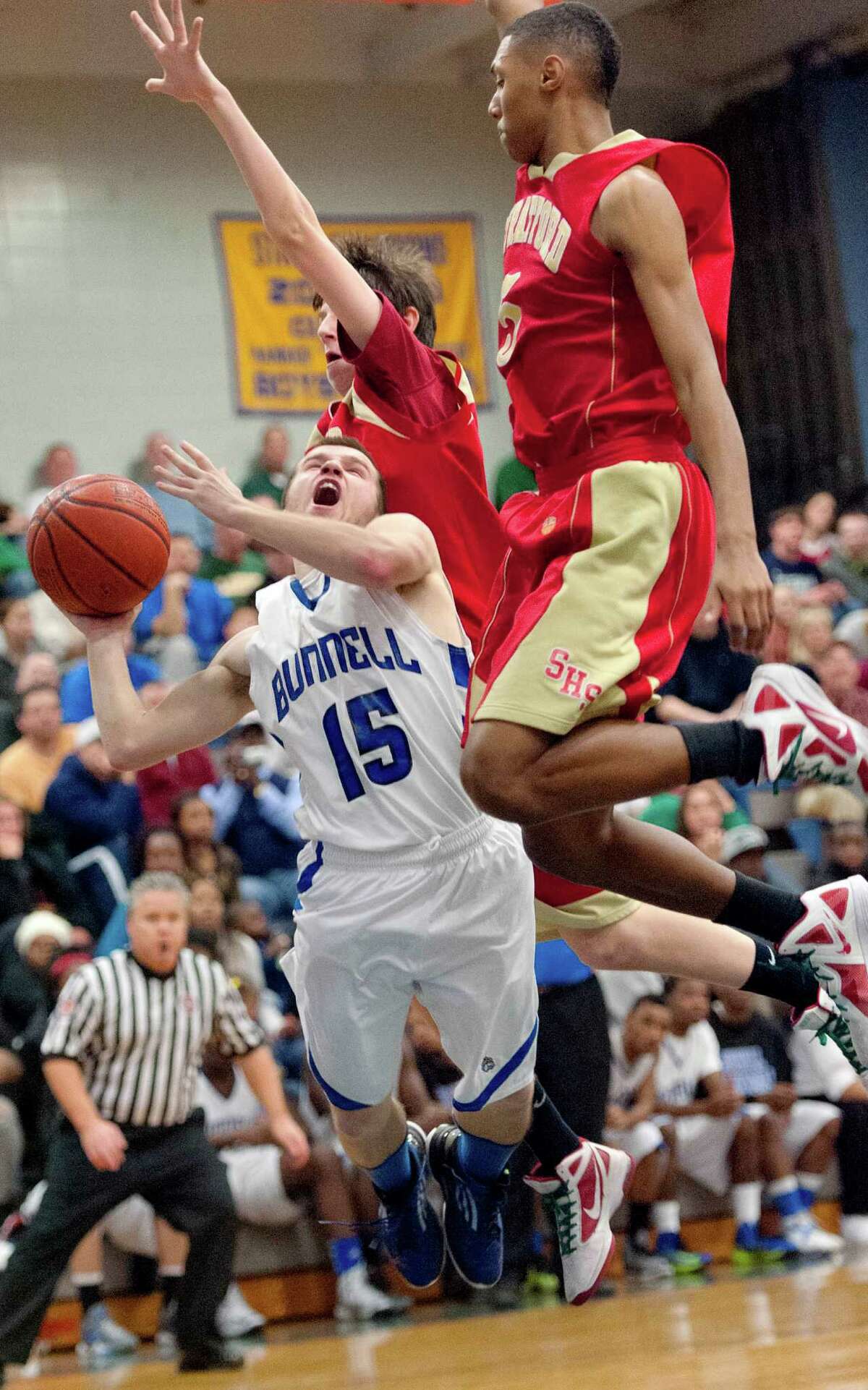Stratford high school's Emmanuel Young and Arron Smith try to stop Bunnell high school's Timothy White from going up for a shot in a boys basketball game played at Bunnell high school, Stratford, CT on Saturday, December 22nd, 2012.