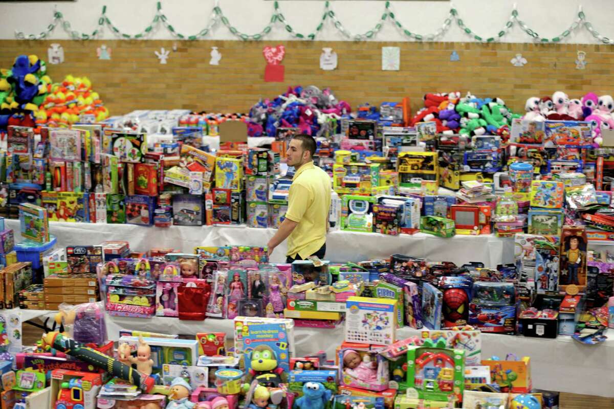Volunteer Anthony Vessicchio of East Haven, Conn., helps to sort tables full of donated toys at the town hall in Newtown, Conn., Friday, Dec. 21, 2012. (AP Photo/Seth Wenig)