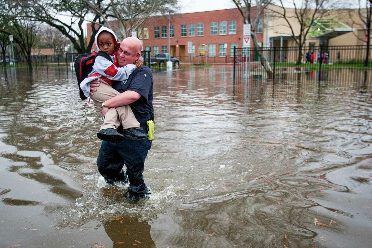 Houston firefighter Scotch Blair carries Dezmund Chapman, 5, through floodwaters to his parents after heavy rain flooded the streets around Peck Elementary Monday, Jan. 9, 2012, in Houston.