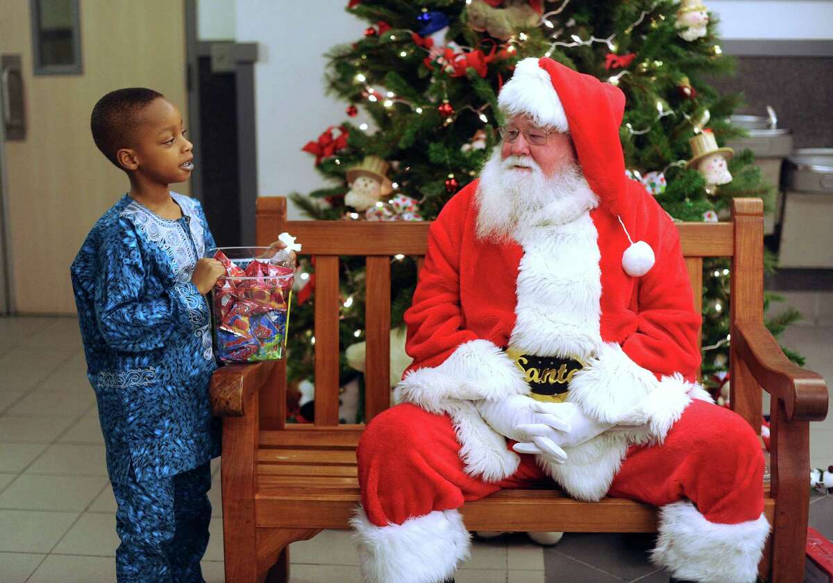 Five-year-old Troy Okhiria converses with Santa Claus during the annual Christmas party for Nigerian children of San Antonio at St. Matthew Catholic Church on Saturday night, Dec. 22, 2012. The event was sponsored by professional Nigerian immigrant women.