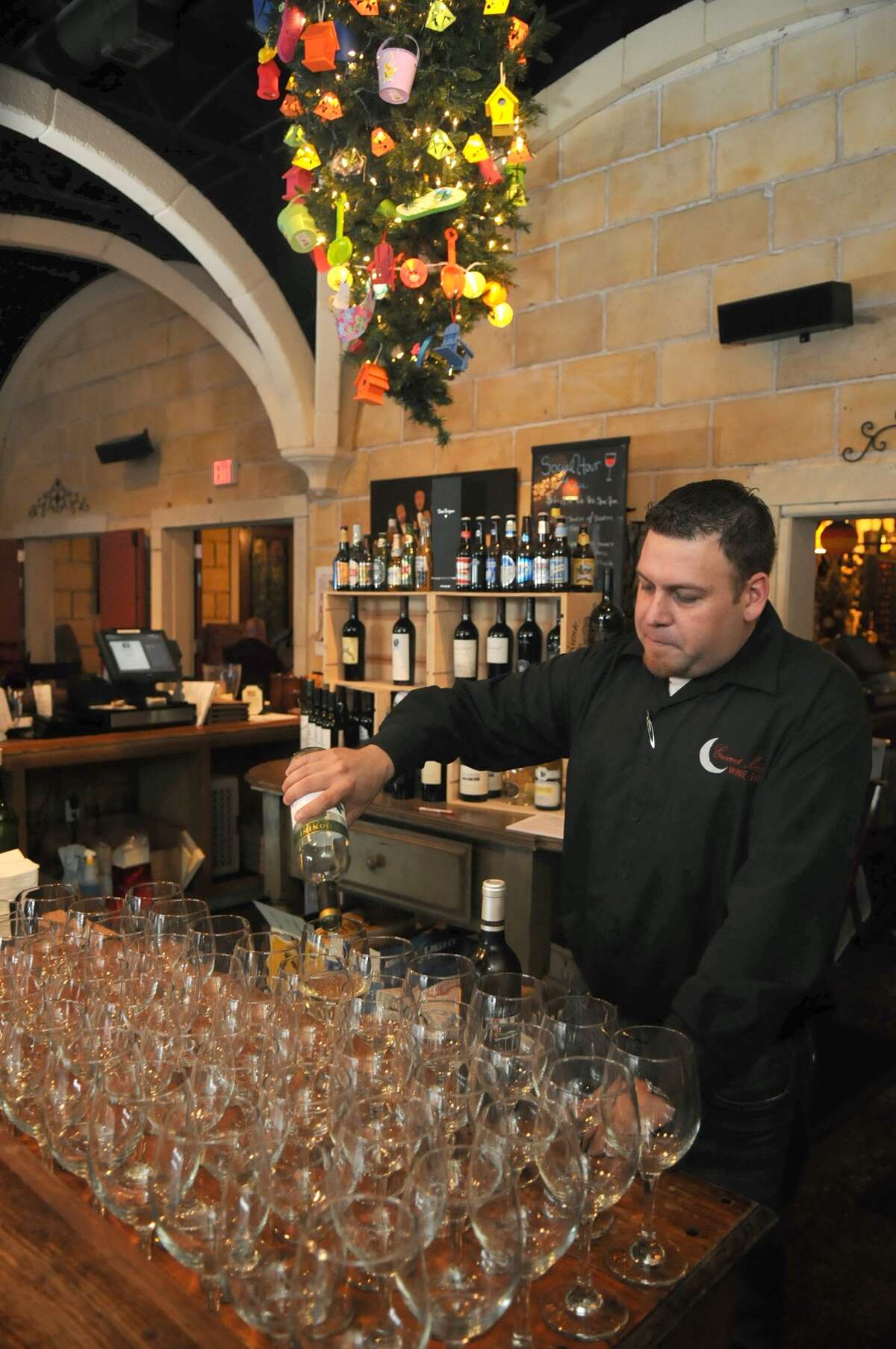 Manager Mike Cantu pours a glass of wine at the Crescent Moon Wine Bar and Restaurant in Spring.