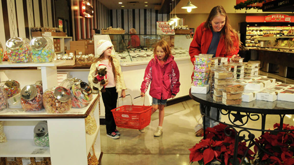 Jenny Coats, 8, from left, Jacelyn Dilby, 7, and Jenny's mom, Kirsten, of The Woodlands, check out one of the displays at the See's Candies shop at H-E-B Woodlands Market.